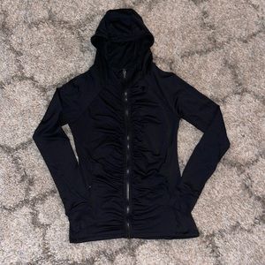 Black zip up jacket with hood pockets that zip and rooshing down the front.
